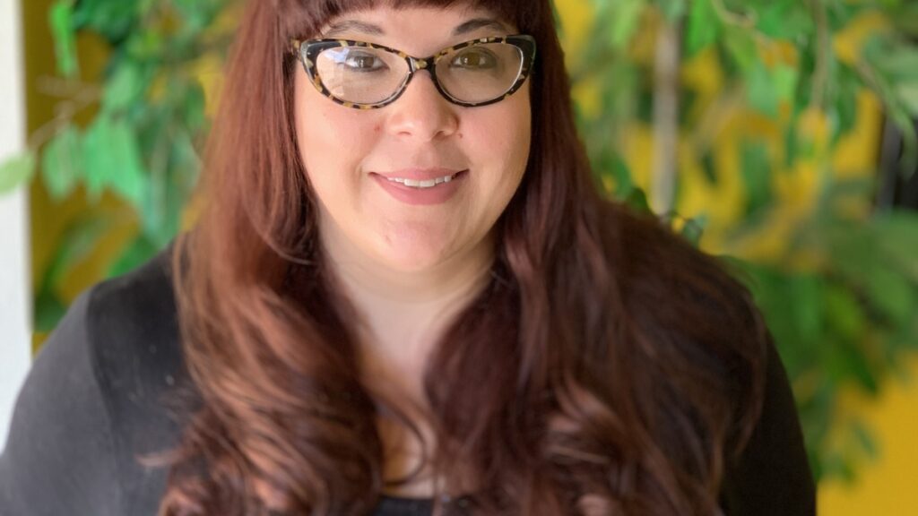 A woman wearing glasses and black clothes.