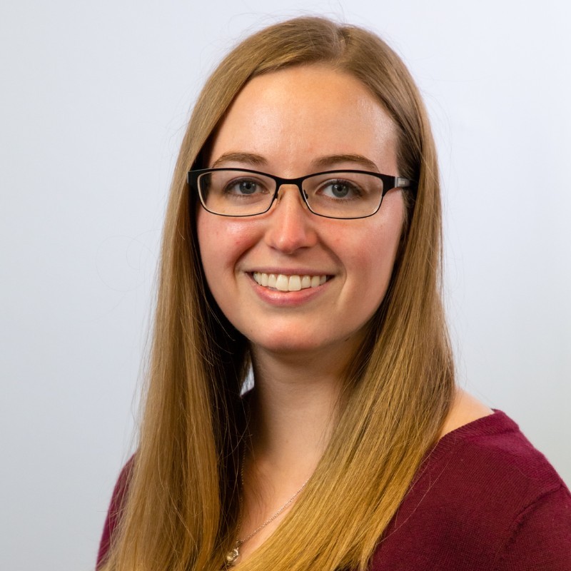 A woman in glasses and red shirt.