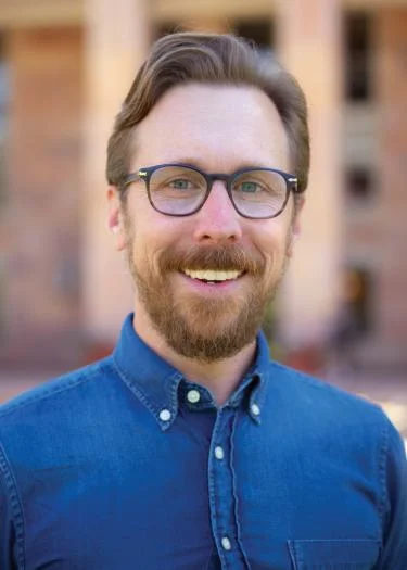 A man with a blue shirt and glasses.