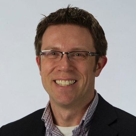 A man wearing glasses and a suit.