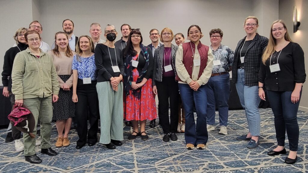 Group of APTrust members standing together and smiling in a conference room at the 2025 Fall Membership Meeting in Chicago.